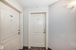 Entryway featuring two panel doors with classic trim, light gray painted walls, and textured dark flooring - 