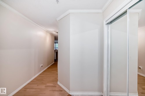 Hallway featuring wood-finish flooring and crown molding - 214 9938 104 Street, Edmonton, AB 