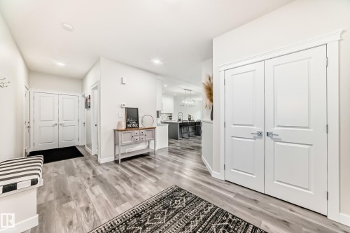 Entryway featuring wood-finish flooring, recessed lighting, and a white paneled double-door closet with chrome hardware - 589 Boulder Wynd, Leduc, AB - Indoor Photo Showing Other Room