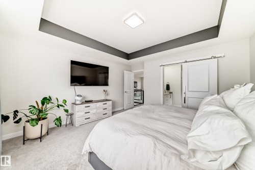 Bedroom with tray ceiling, flush-mount lighting, and light gray carpet flooring - 589 Boulder Wynd, Leduc, AB - Indoor Photo Showing Bedroom