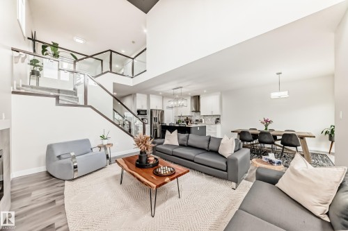 Expansive open-concept living area featuring high ceilings and wood-finish flooring - 589 Boulder Wynd, Leduc, AB - Indoor Photo Showing Living Room