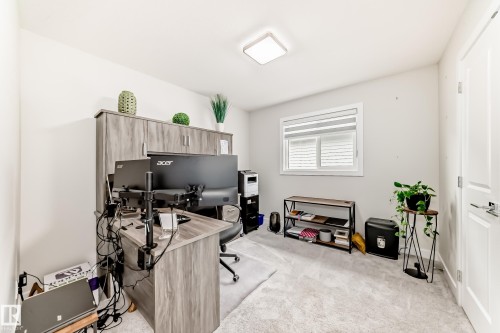 Light-filled room featuring a broad window, light gray carpeting, and a flush-mount ceiling light - 589 Boulder Wynd, Leduc, AB - Indoor