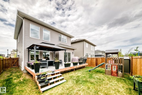 Expansive backyard featuring a large wood-finish deck with steps, a black gazebo, and a full wood privacy fence - 589 Boulder Wynd, Leduc, AB - Outdoor