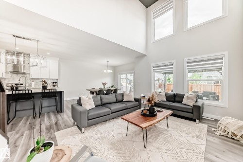 Spacious living area featuring a vaulted ceiling and multiple large windows - 589 Boulder Wynd, Leduc, AB - Indoor Photo Showing Living Room