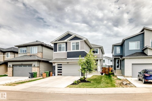 Two-story residence featuring a multi-toned exterior with horizontal siding and stone accents - 589 Boulder Wynd, Leduc, AB - Outdoor With Facade