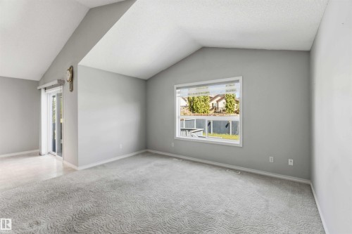 Vaulted ceiling room featuring light gray walls and patterned carpeting - 2012 35A Avenue, Edmonton, AB 