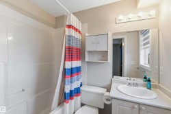 Full bathroom featuring a single vanity, integrated sink, and white cabinetry - 