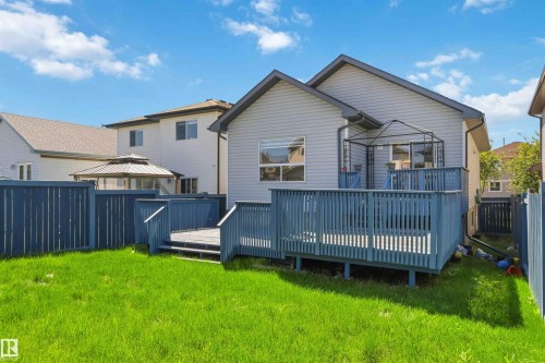 Expansive backyard featuring a manicured lawn, a full wooden deck with railings, and privacy fencing - 2012 35A Avenue, Edmonton, AB 
