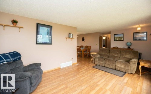 Open-concept living area featuring wood-finish flooring, neutral wall tones, and recessed built-in shelving - 57532 Rg Rd 270, Rural Westlock County, AB 