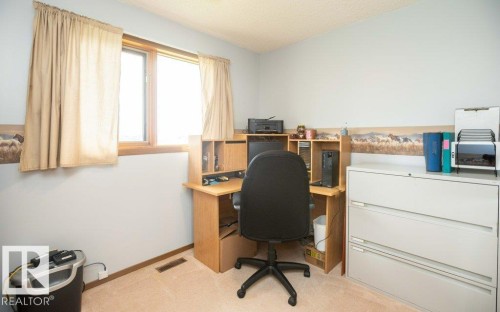 Carpeted room featuring a light wall color, wood-trimmed window, and a textured ceiling - 57532 Rg Rd 270, Rural Westlock County, AB 