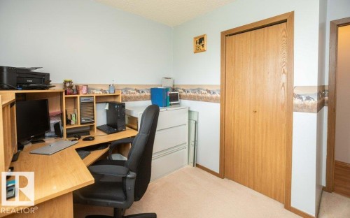 Carpeted room featuring a light blue wall color, wood-finish bi-fold closet doors, and wood-finish trim - 57532 Rg Rd 270, Rural Westlock County, AB 
