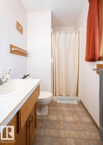 Bathroom featuring a single vanity with wood cabinetry, a white countertop, and an integrated sink - 57532 Rg Rd 270, Rural Westlock County, AB 