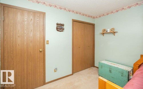 Room featuring wood-finish doors, soft green wall paint, and beige carpeting - 57532 Rg Rd 270, Rural Westlock County, AB 