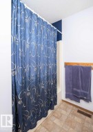 Tub/shower combination featuring a tiled surround and light-toned flooring - 