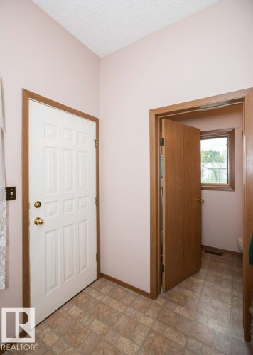 Entryway featuring patterned tile flooring and a paneled white door with brass hardware - 57532 Rg Rd 270, Rural Westlock County, AB 
