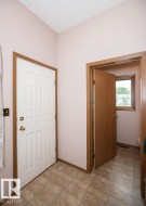 Entryway featuring patterned tile flooring and a paneled white door with brass hardware - 