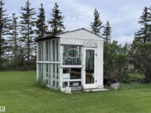Freestanding greenhouse structure with paneled glass sections and a white paneled door - 57532 Rg Rd 270, Rural Westlock County, AB 