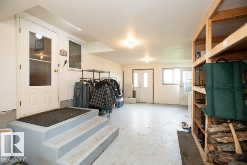 Spacious utility area featuring exposed concrete flooring, white walls, and multiple entry points - 57532 Rg Rd 270, Rural Westlock County, AB 