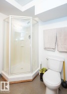 Corner shower enclosure with clear glass panels and chrome fixtures - 