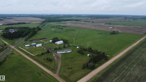 Expansive acreage featuring a white residence, multiple outbuildings, and extensive green fields - 57532 Rg Rd 270, Rural Westlock County, AB 