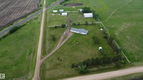 Rural acreage featuring a single-story residence with dark roofing, multiple outbuildings, and extensive green space - 57532 Rg Rd 270, Rural Westlock County, AB 