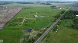 Expansive rural property featuring cultivated fields, natural ponds, and established tree lines - 