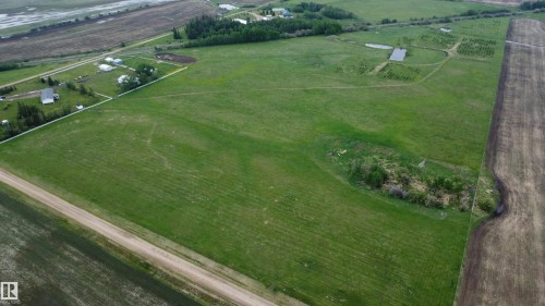 Expansive green land parcel featuring a dirt road border, cultivated fields, and a distant treeline - 57532 Rg Rd 270, Rural Westlock County, AB 