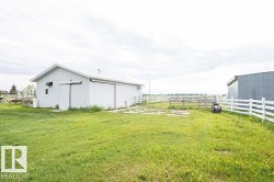 White outbuilding with a gable roof and white siding - 