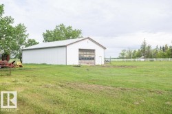 White metal outbuilding with a roll-up garage door and an additional pedestrian door - 