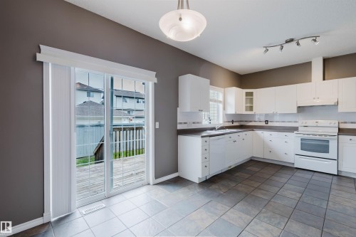 Kitchen featuring white cabinetry, a built-in oven range, and a dishwasher - 38 1780 Glastonbury Boulevard, Edmonton, AB 