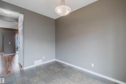 Room featuring gray tile flooring, neutral wall paint, and white baseboards - 