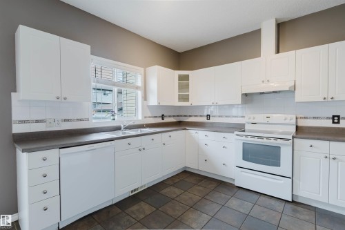 Kitchen featuring white cabinetry, gray countertops, and tiled flooring - 38 1780 Glastonbury Boulevard, Edmonton, AB 