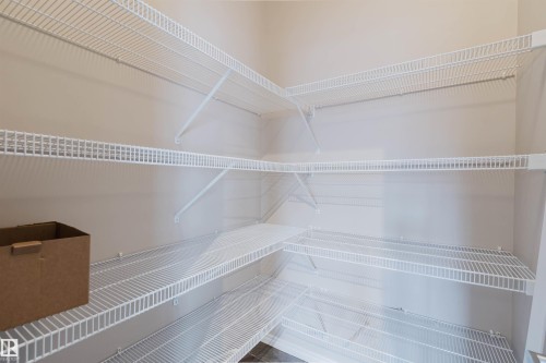 Corner pantry featuring multiple white wire shelving units - 38 1780 Glastonbury Boulevard, Edmonton, AB 