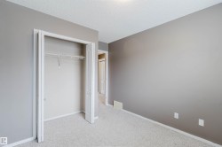 Carpeted room with a bi-fold door closet featuring a wire shelf and hanging rod - 