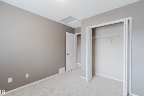 Neutral-toned interior room featuring light-colored carpet flooring - 38 1780 Glastonbury Boulevard, Edmonton, AB 