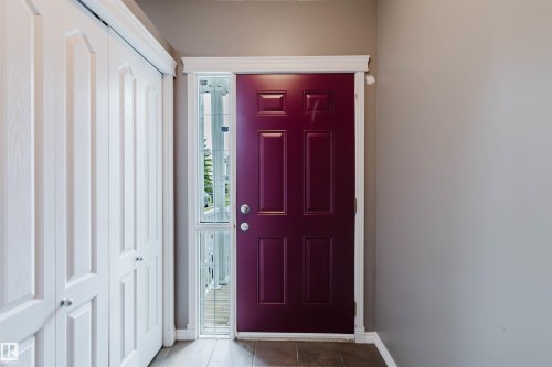 Panel door with sidelight entry, featuring a deep red finish - 38 1780 Glastonbury Boulevard, Edmonton, AB 