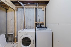 Utility area featuring exposed concrete walls and overhead piping - 