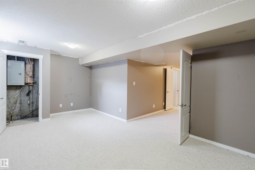 Spacious room featuring light-colored carpeting, neutral gray walls, and white trim - 38 1780 Glastonbury Boulevard, Edmonton, AB 