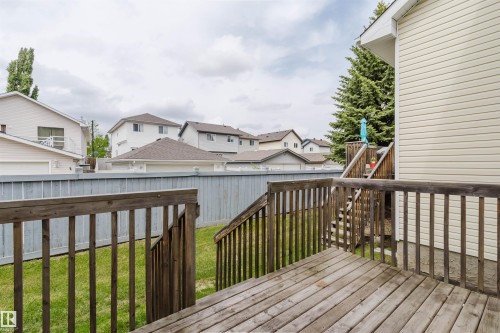 Rear exterior with wood decking and stairs leading to a lower-level landing - 38 1780 Glastonbury Boulevard, Edmonton, AB 