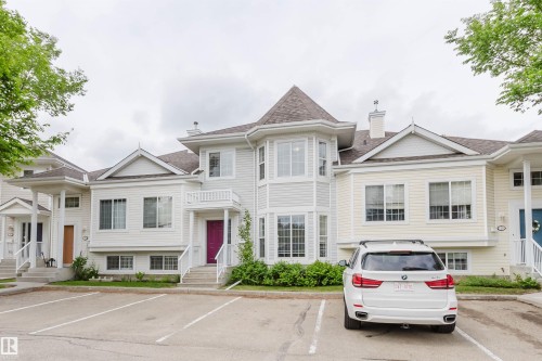 Multi-level townhome exterior featuring light-colored siding, a prominent turret-style window feature, multiple gables, and a pitched roof - 38 1780 Glastonbury Boulevard, Edmonton, AB 