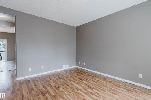 Open concept room featuring wood-finish flooring, light grey walls, and white baseboards - 38 1780 Glastonbury Boulevard, Edmonton, AB 