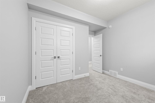 Neutral gray carpeting and walls with white baseboards create a refined interior - 389 Charlesworth Drive, Edmonton, AB 