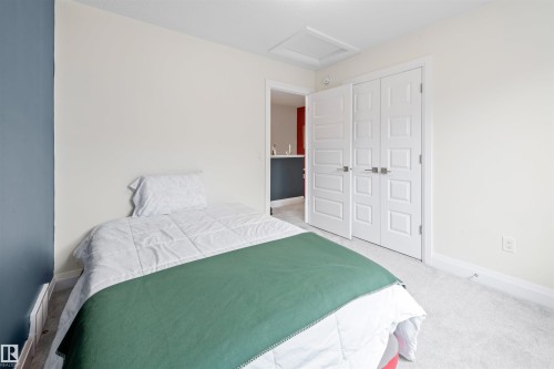 Carpeted room with white trim, a two-tone wall, and white bi-fold closet doors - 389 Charlesworth Drive, Edmonton, AB 