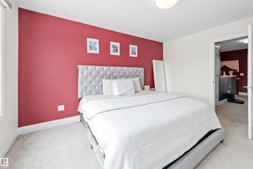 Carpeted bedroom with a single accent wall and white trim - 389 Charlesworth Drive, Edmonton, AB 