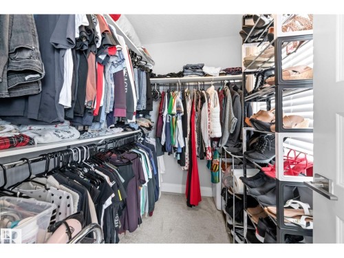 Walk-in closet featuring extensive built-in shelving and hanging rods - 389 Charlesworth Drive, Edmonton, AB 