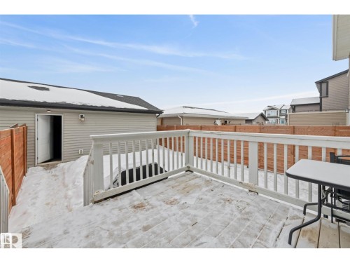 Expansive rear deck featuring a white railing system, wood-finish decking, and direct access to the rear yard - 389 Charlesworth Drive, Edmonton, AB 