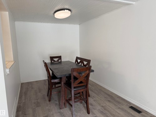 Dining area featuring wood-finish flooring, white painted walls, and a beadboard ceiling - 14537 121 Street, Edmonton, AB 