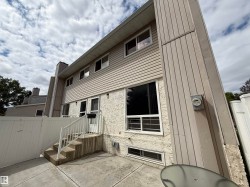 Exterior featuring horizontal siding, textured stucco accents, a concrete patio, and a white privacy fence - 