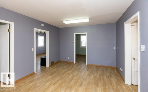 Interior space featuring light wood-finish flooring and multiple doorways - 9836 100 Street, Westlock, AB 