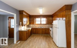 Kitchen featuring extensive wood-finish cabinetry, light-toned countertops, and a tile backsplash - 